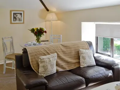 a living room with a couch with a blanket on it at Rosecraddoc Manor - Hayloft in Saint Cleer