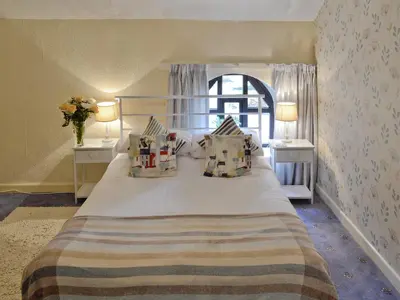 a bedroom with a large bed with two night stands at Rosecraddoc Manor - Hayloft in Saint Cleer