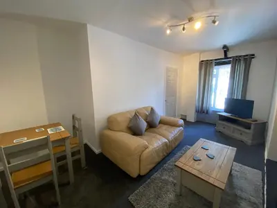 a living room with a couch and a table at Rosecraddoc Manor - Coachman's in Saint Cleer
