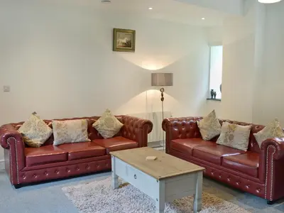 a living room with two leather couches and a coffee table at Rosecraddoc Manor - Stable in Saint Cleer