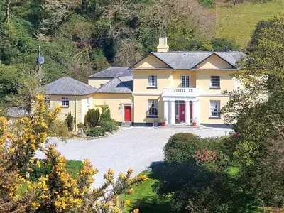 an aerial view of a large yellow house with a driveway at Rosecraddoc Manor - Heron in Saint Cleer