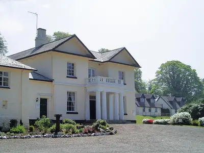 a large white house with a driveway at Rosecraddoc Manor - Heron in Saint Cleer