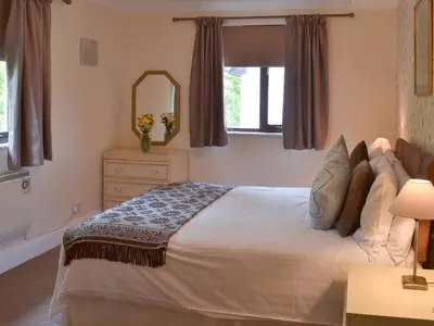 a bedroom with a large bed and a mirror at Rosecraddoc Manor - Lakeview in Saint Cleer