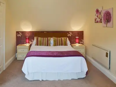 a bedroom with a large bed with two night stands at Rosecraddoc Manor - Lakeview in Saint Cleer