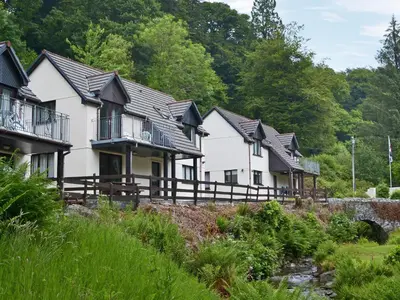 a row of houses with trees in the background at Rosecraddoc Manor - Riverview in Saint Cleer