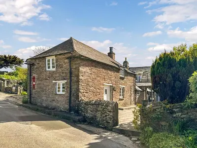 an old brick house on the side of a street at Pillar Box Cottage in Tintagel