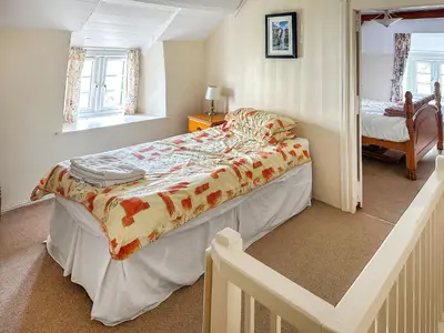 a bedroom with a large bed in a room at Pillar Box Cottage in Tintagel