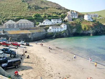 a group of people on a beach near the water at Pillar Box Cottage in Tintagel