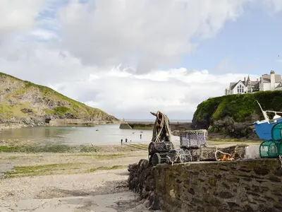 a beach with a group of chairs on the shore at Pillar Box Cottage in Tintagel