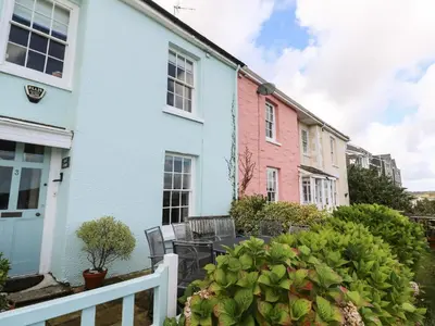 a row of colourful houses with a white fence at April Cottage in Falmouth
