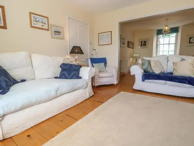 a living room with two white couches and a chair at April Cottage in Falmouth