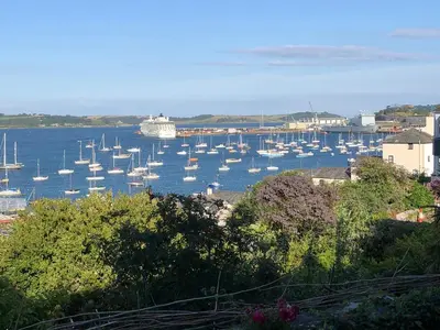 a bunch of boats in a harbor with a cruise ship at April Cottage in Falmouth