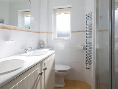 a white bathroom with a sink and a toilet at Moorlands Bungalow in Wadebridge