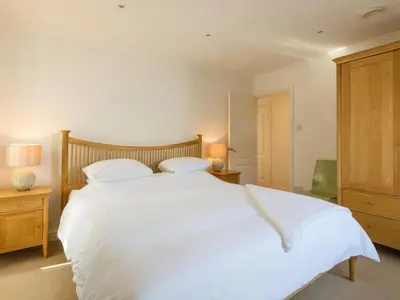 a bedroom with a large white bed with two pillows at Moorlands Bungalow in Wadebridge