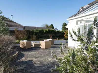 a patio with cardboard furniture next to a house at Moorlands Bungalow in Wadebridge
