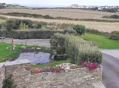 a garden with a pond in the middle of a road at The Old Barn in Tintagel