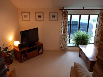 a living room with a flat screen tv and a couch at The Old Barn in Tintagel