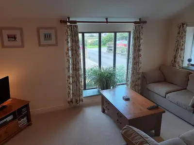 a living room with a couch and a coffee table at The Old Barn in Tintagel