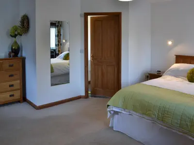 a bedroom with a bed and a mirror at Eglos Derry Farm Cottage - E4597 in Cury