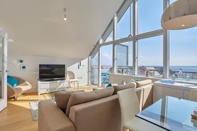 a living room with a couch and a television at Stunning Apartment Balcony Sea Views St Ives in St Ives