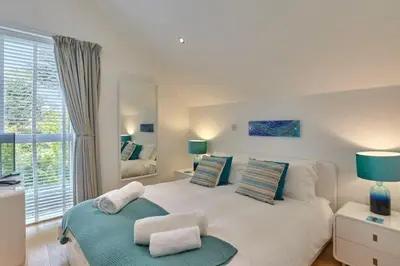 a bedroom with a large white bed with a mirror at Stunning Apartment Balcony Sea Views St Ives in St Ives