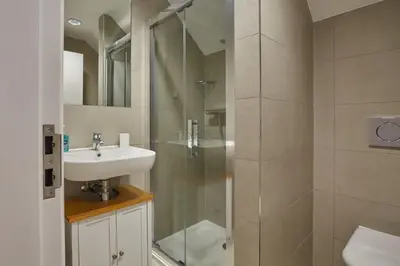 a bathroom with a sink and a glass shower at Stunning Apartment Balcony Sea Views St Ives in St Ives