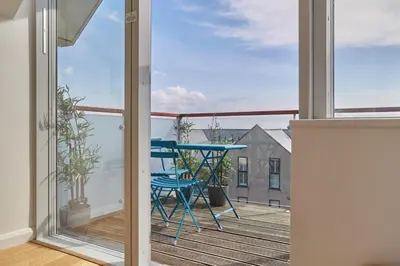 a balcony with a blue table and chairs on a deck at Stunning Apartment Balcony Sea Views St Ives in St Ives