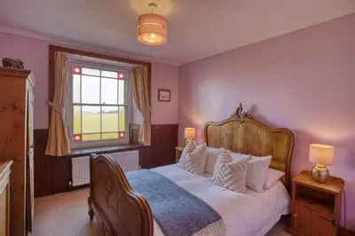 a bedroom with a large bed and a window at Historic Chapel Great Facilities nr Beaches in Saint Ewe