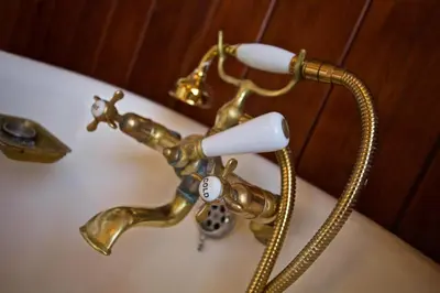 a bathroom sink with a gold faucet with a toothbrush at Historic Chapel Great Facilities nr Beaches in Saint Ewe