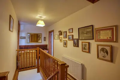 a hallway with a staircase with pictures on the wall at Historic Chapel Great Facilities nr Beaches in Saint Ewe