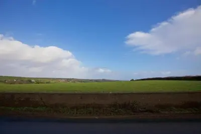 a view of a green field from the side of a road at Historic Chapel Great Facilities nr Beaches in Saint Ewe