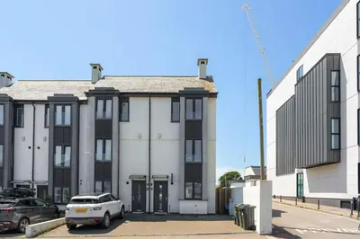 a building with a car parked in front of it at Townhouse Parking 1 Min Walk to Tolcarne Beach in Newquay