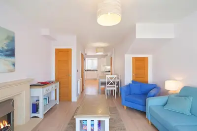 a living room with a blue couch and a fireplace at Townhouse Parking 1 Min Walk to Tolcarne Beach in Newquay