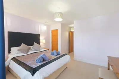 a bedroom with a large bed with blue pillows on it at Townhouse Parking 1 Min Walk to Tolcarne Beach in Newquay