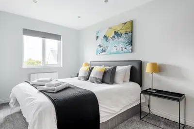 a bedroom with a large white bed and a window at Modern House in St Agnes Parking & Garden in St. Agnes
