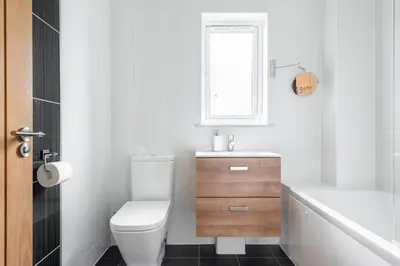 a bathroom with a toilet and a sink and a tub at Modern House in St Agnes Parking & Garden in St. Agnes