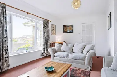 a living room with a couch and a large window at Peaceful Home in Looe with Stunning Views in Looe