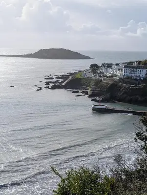 a boat is docked on the shore of a body of water at Peaceful Home in Looe with Stunning Views in Looe