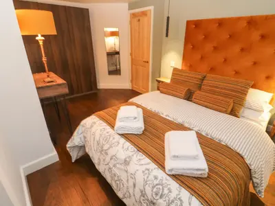 a bedroom with a large bed with two towels on it at Dowager Cottage in Penryn