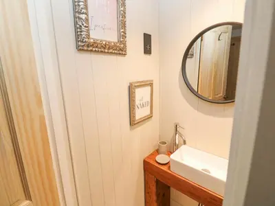 a bathroom with a sink and a mirror at Dowager Cottage in Penryn