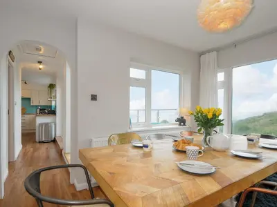 a kitchen and dining room with a wooden table at Waves Edge in Torpoint