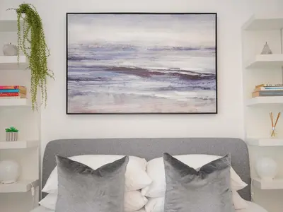 a living room with a couch and a painting on the wall at Waves Edge in Torpoint