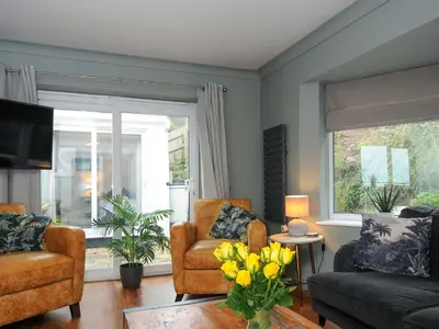 a living room with a couch and a chair and a window at Waves Edge in Torpoint