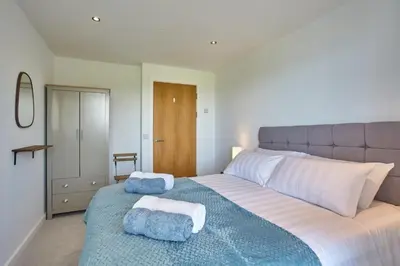 a bedroom with a large bed with towels on it at Apartment Sea Views 5 mins Walk to Fistral in Newquay