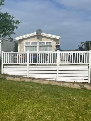 a white fence in front of a house at 62 Newquay Bay Resort Pet Friendly in Newquay