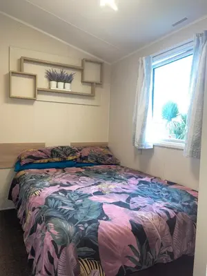 a bedroom with a bed with a colorful blanket at 62 Newquay Bay Resort Pet Friendly in Newquay