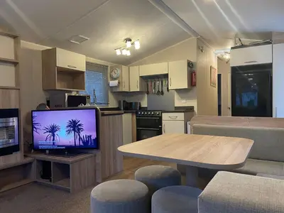 a kitchen and a living room with a tv and a table at 62 Newquay Bay Resort Pet Friendly in Newquay