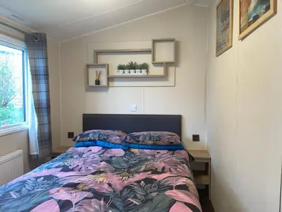 a bedroom with a bed with a colorful comforter at 62 Newquay Bay Resort Pet Friendly in Newquay