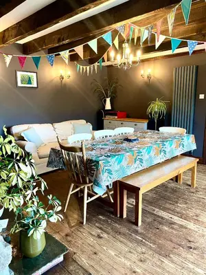 a dining room with a table and chairs and flags at The Hay Loft in Bude