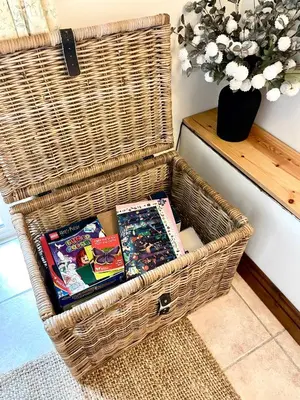 a wicker basket with books in it next to a table at The Hay Loft in Bude